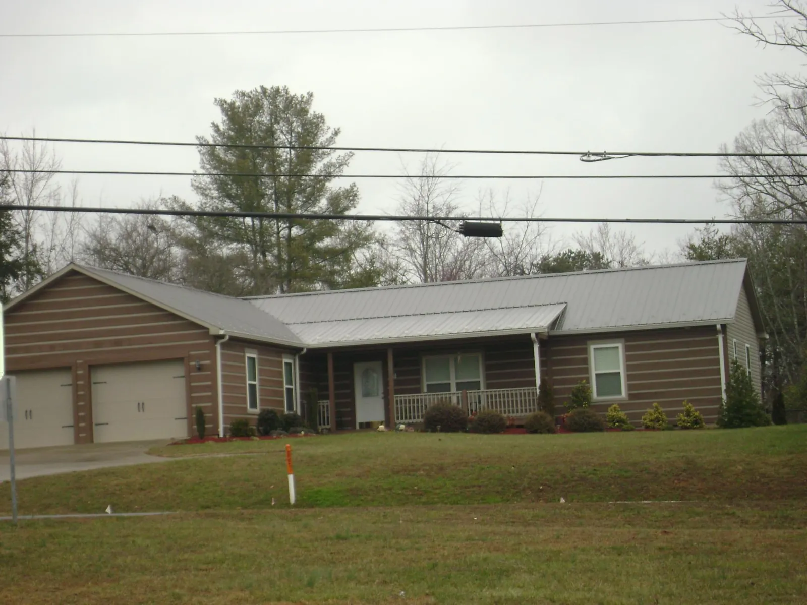 Gray metal roof on a log sided ranch home with a front porch in Moscow